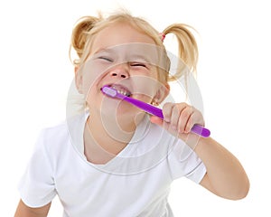 A little girl brushes her teeth.