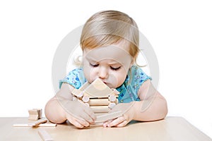 Little girl building toy house