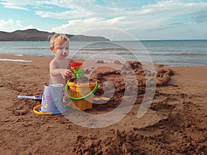 Little girl builds a sand castle