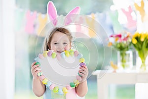 Little girl in bunny ears on Easter egg hunt