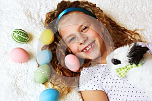 little girl with a bunny rabbit has a easter at white carpe