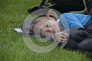 Little girl camping with sleeping bag