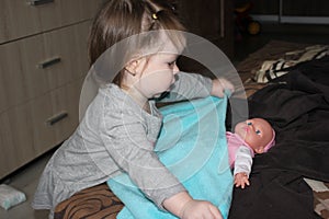 Little girl carefully harboring a doll