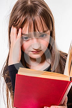 Little girl carefully reading a book