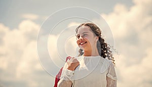 little girl carry backpack. small kid on sunny sky background. summer and spring season. holiday and vacation. happy