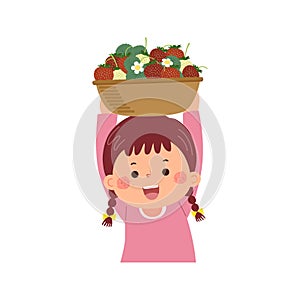 Little girl carrying basket full of ripe strawberries