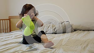 A little girl with a cast on her leg is naughty while sitting in bed.