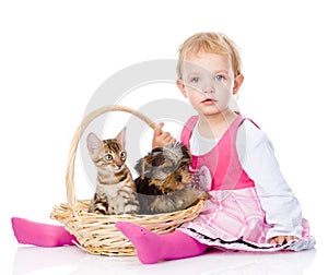 Little girl with a cat and a dog sitting in a basket.