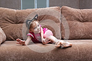 Little girl with cat face painting on couch