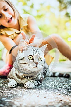 Little girl with a cat outdoors