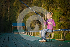 Little girl catches fishing rod