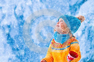 Little girl catching snow flakes