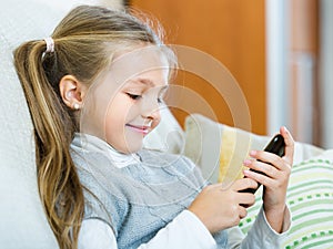 Little girl with cell phone indoors