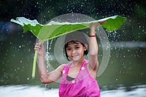 The little girl cheerful playing raining photo