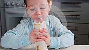 little girl child eating fast food home made enjoys the taste at kitchen