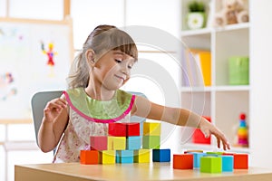 Little girl child kid playing with building blocks