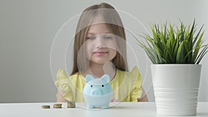 Little girl child put coins into piggy bank saving for future needs. Happy smart small 9s teen kid make donation