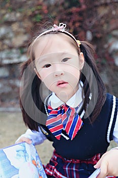 Little girl Child reading a book on the grass