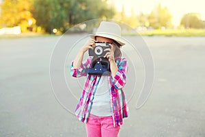 Little girl child with retro camera doing snapshot
