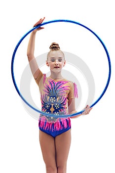 Little girl, child, rhythmic gymnastics athlete in stage costume standing with gymnastic hoop against white studio