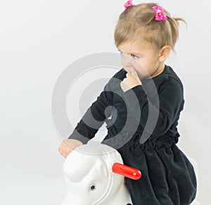 The little girl child riding Toy horse