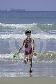 Little girl child running in to the sea water