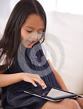 Little girl, child and tablet on sofa for entertainment, movie or online streaming in living room at home. Face of