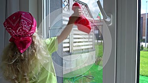 Little girl child washes window at home. Gimbal motion