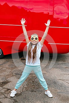 Little girl child wearing funny sunglasses jumping in over city background