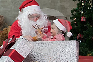 Little girl childhood cute happy smiling delighted with a gift box from Uncle Santa Claus