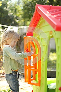 Little girl with a children's playhouse