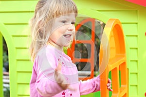 Little girl with a children's playhouse
