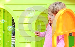 Little girl with a children's playhouse