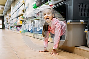 Little girl chooses carrier for puppy in pet shop