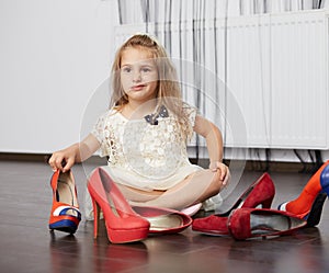 Little girl choosing mother shoes