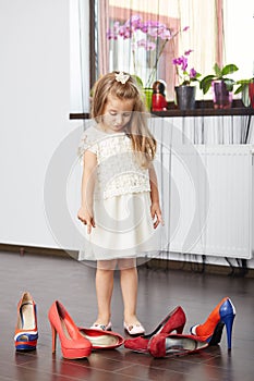 Little girl choosing mother shoes