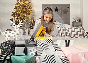 Little girl at christmas opens gifts