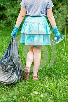 Little girl cleans plastic trash