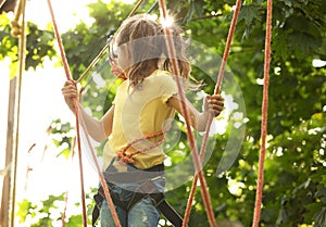 Little girl climbing in adventure park