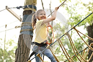 Little girl climbing in adventure park