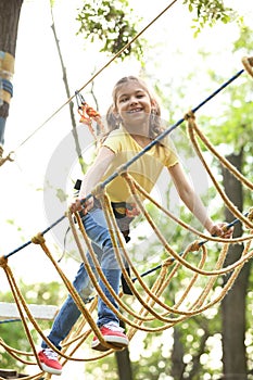 Little girl climbing in adventure park