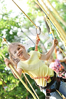 Little girl climbing in adventure park