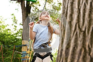 Little girl climbing in adventure park