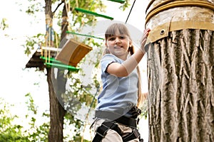 Little girl climbing in adventure park