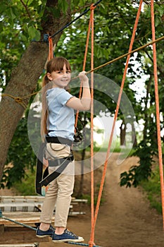 Little girl climbing in adventure park