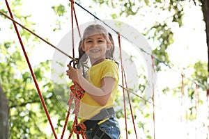 Little girl climbing in adventure park