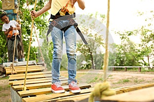 Little girl climbing in adventure park, closeup