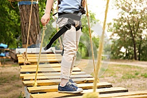 Little girl climbing in adventure park. Summer camp