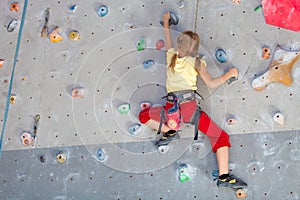 Little girl climbing a rock wall photo