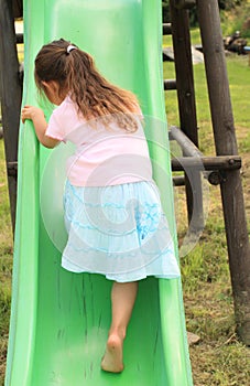 Little girl climbing a slide